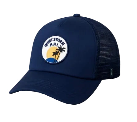 Navy blue cap with a palm tree and sun design on a wooden surface